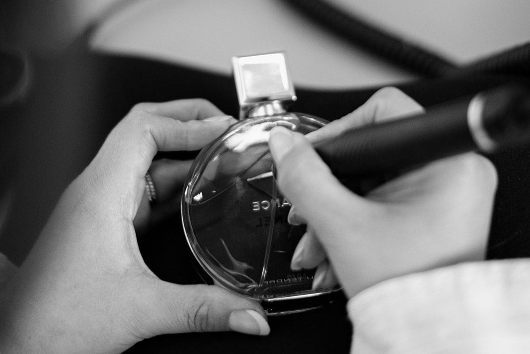 Person holding a perfume bottle with a blurred background
