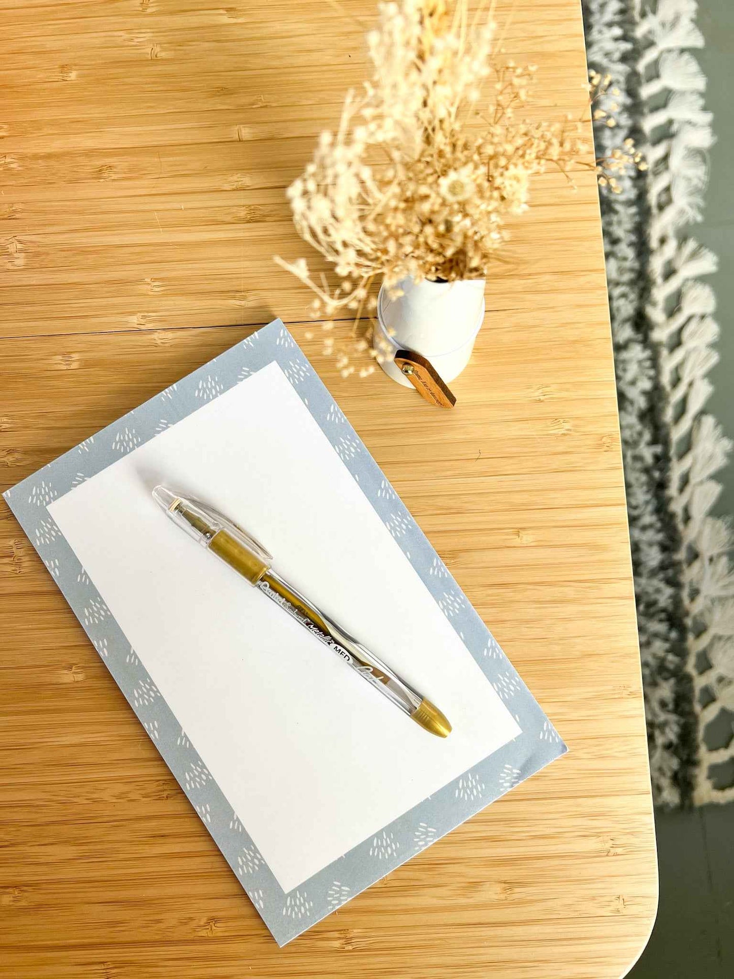 Pretty blue memo pad on desk with pen