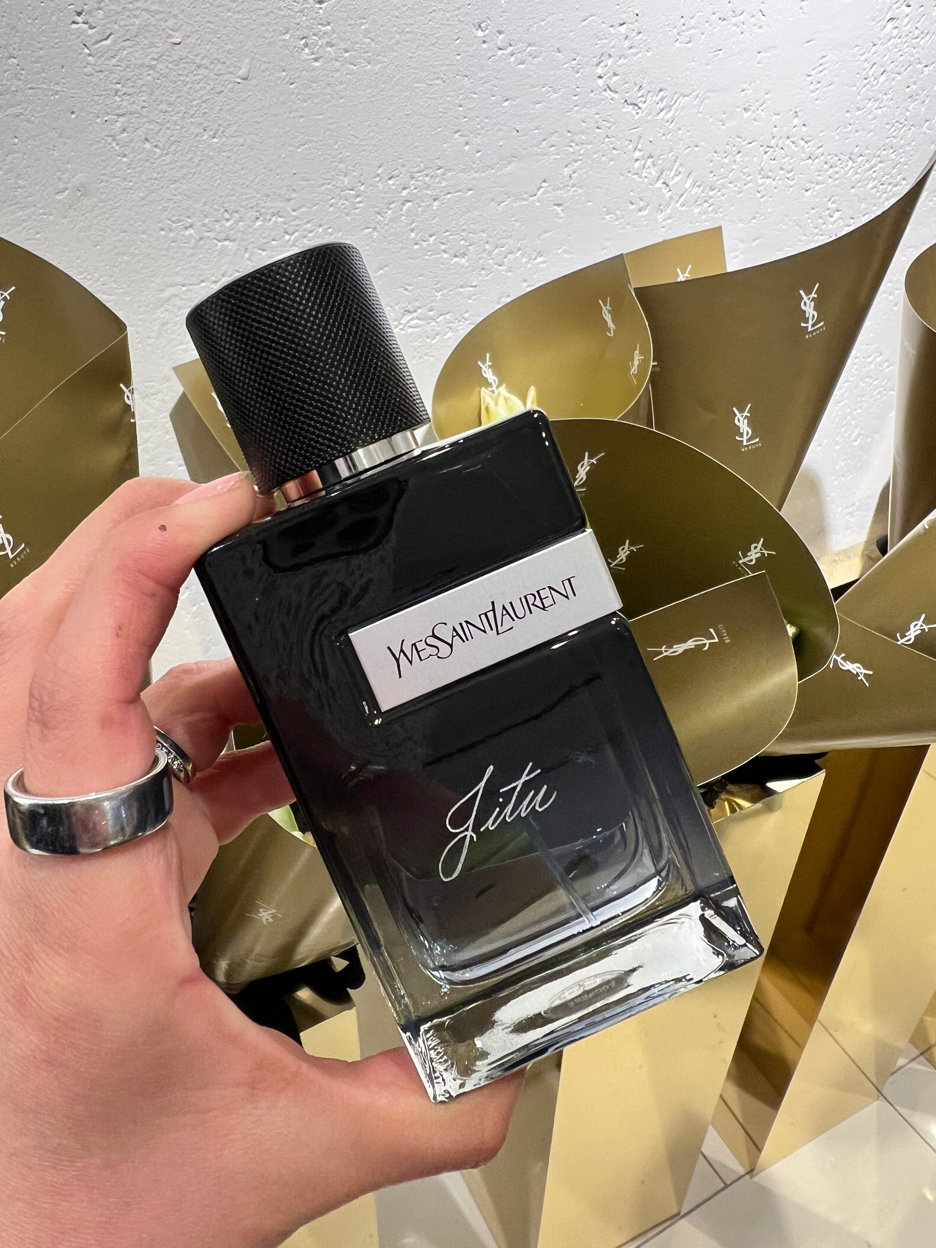 Yves Saint Laurent glass perfume bottle held by a hand with personalized engraving