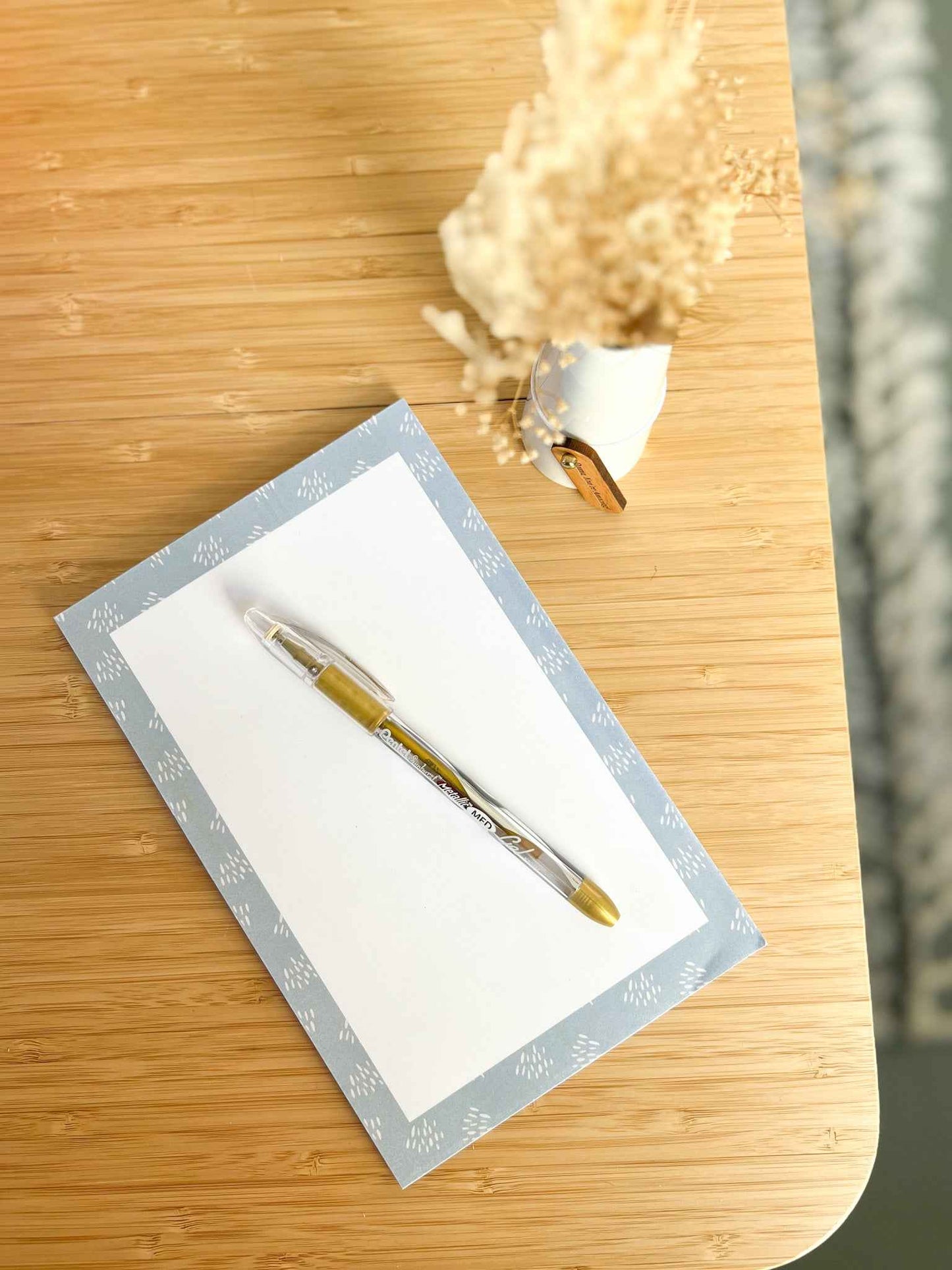 Beautiful blue memo notepad on desk with pretty pen on top